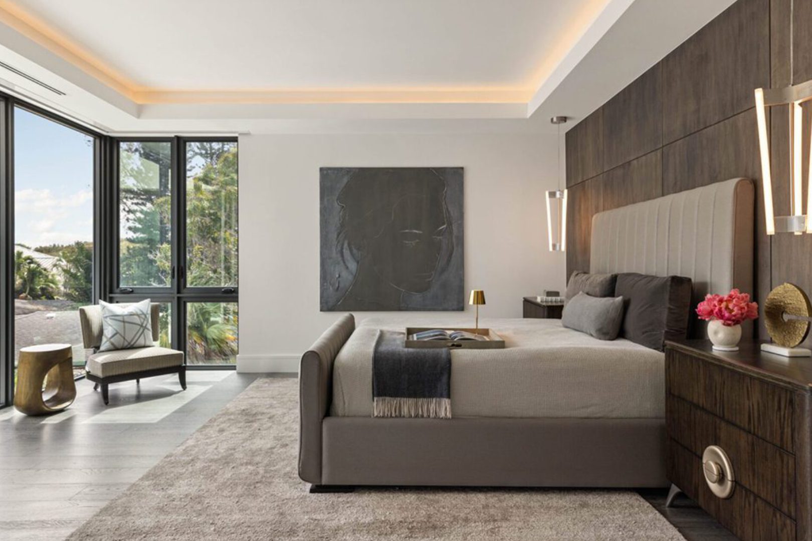Modern bedroom with large windows and artwork.